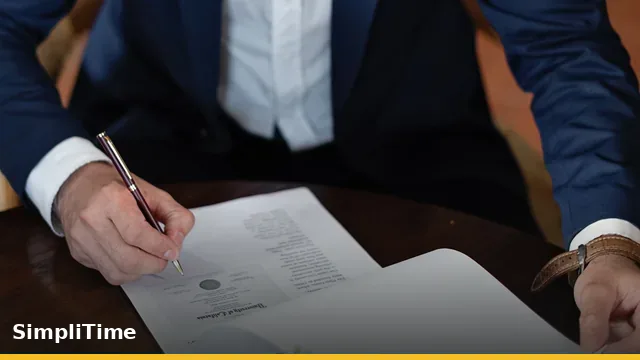 Munkajogi és munkaidő-nyilvántartási dokumentumok áttekintése egy irodai asztalon laptop és jelenléti kimutatások mellett